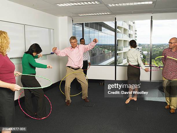 business colleagues twirling plastic hoops - hoelahoep stockfoto's en -beelden