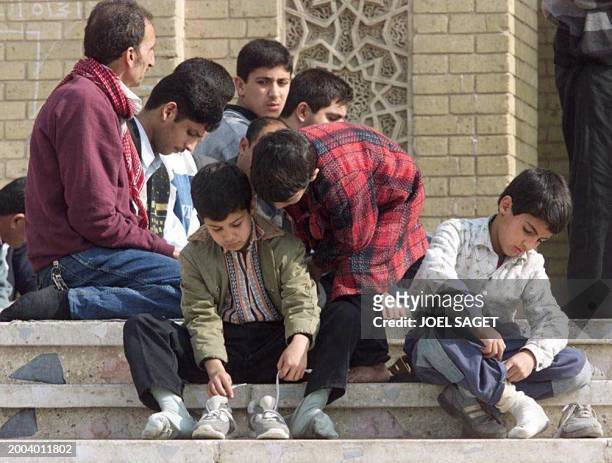 Children remove their shoes before entering a mosque 15 January before the last Friday prayer of the Ramadan holy month. Russia proposed 15 January...