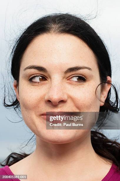 young woman smiling, looking to side, close-up - sourire narquois photos et images de collection