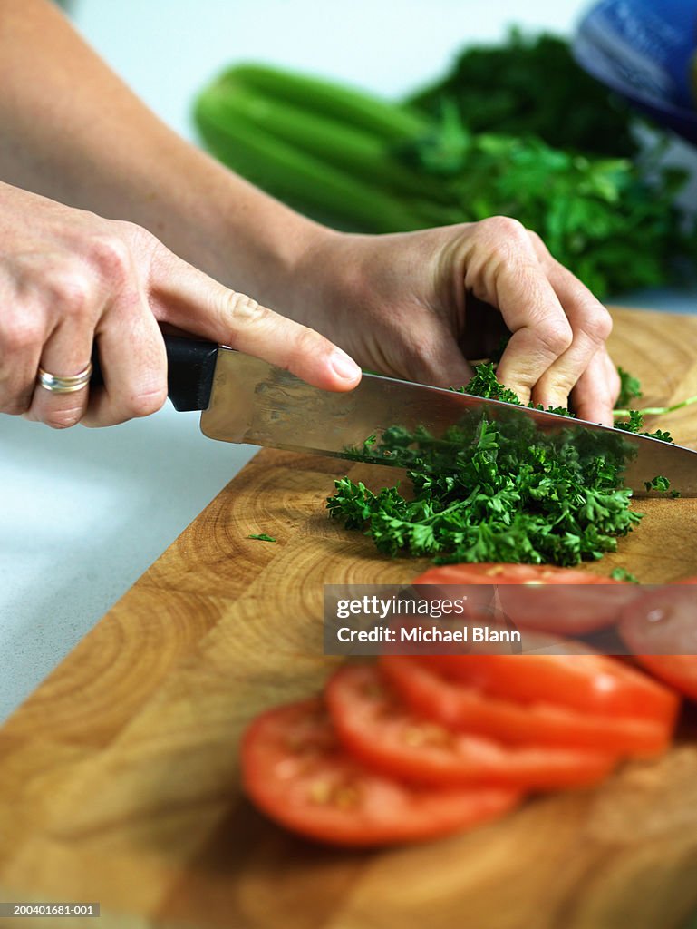 Woman chopping herbs, close-up