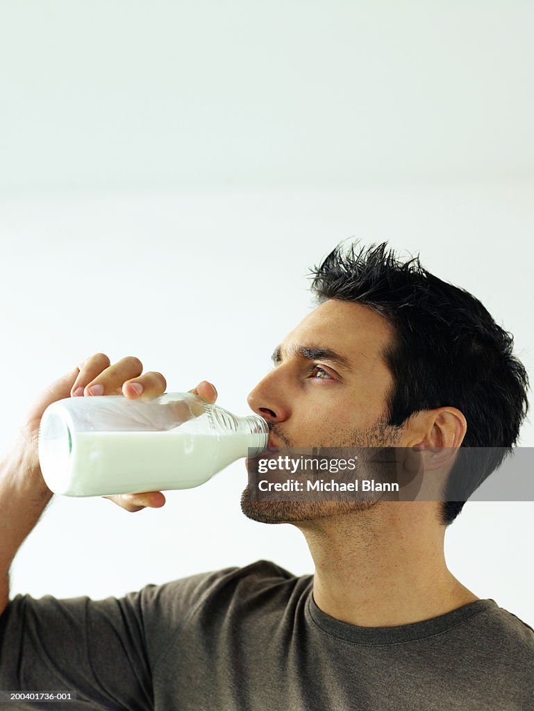 Man drinking bottle of milk, close-up