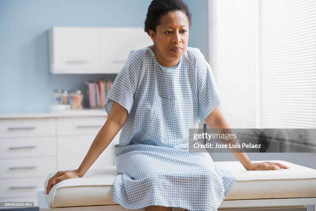 Female patient sitting on examination table in doctor's office