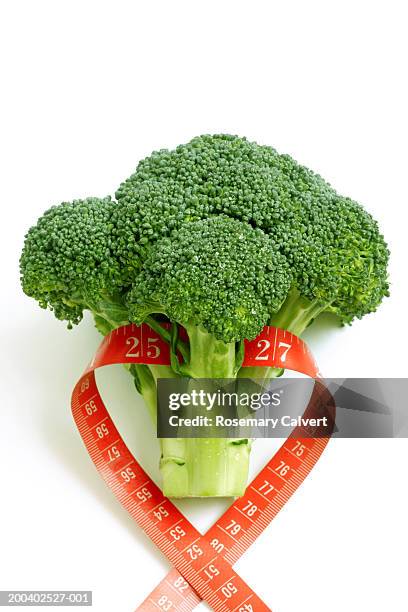 tape measure forming heart-shape around floret of broccoli, close-up - centimeter stock pictures, royalty-free photos & images