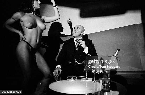 Ex-London gangster Dave Courtney enjoys his champagne and cigar lifestyle while watching a dancer at a London table and pole dancing nightclub, May...