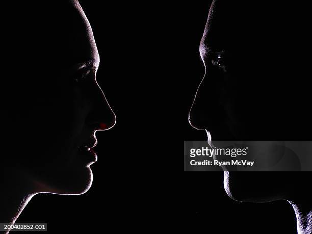 man and young woman looking at one another, profile - faccia a faccia foto e immagini stock