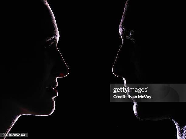 man and young woman looking at one another, profile - gezicht aan gezicht stockfoto's en -beelden