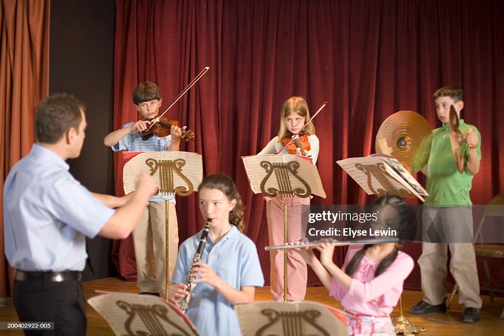 Music teacher instructing school orchestra