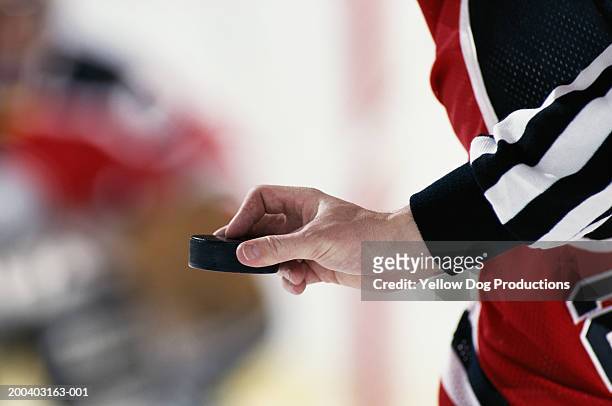 hockey referee poised to put puck into play, close-up - hockey puck stock pictures, royalty-free photos & images