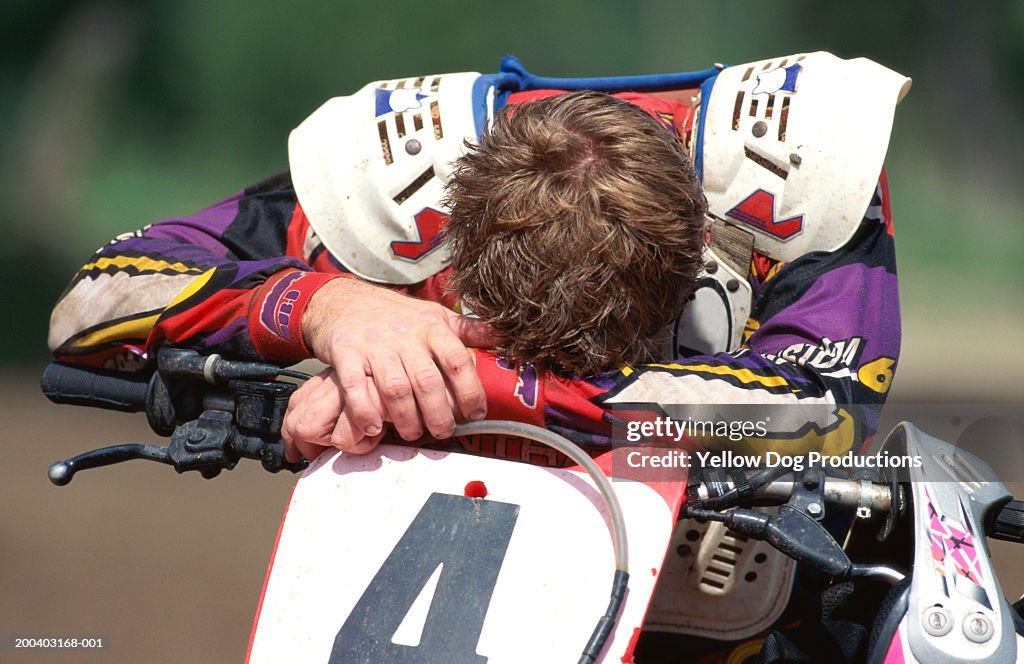Motocross rider laying head on arms