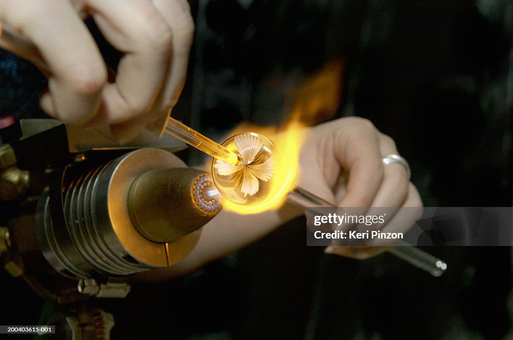 Woman using torch to make glass marble