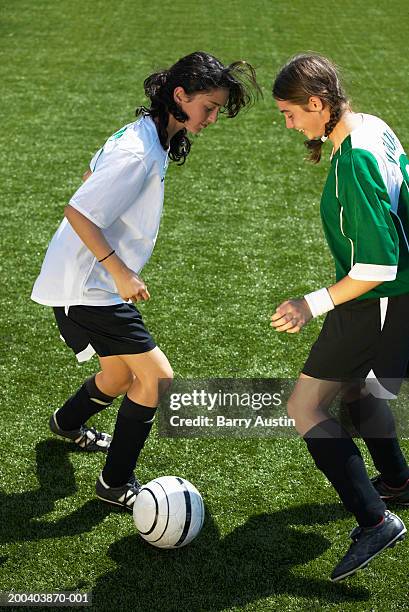 female footballers (11-13) dribbling ball - praticando imagens e fotografias de stock