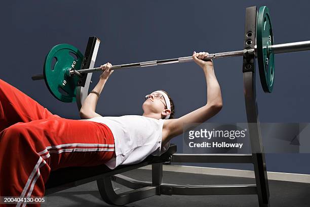 young man about to lift weight in gym - slank stockfoto's en -beelden