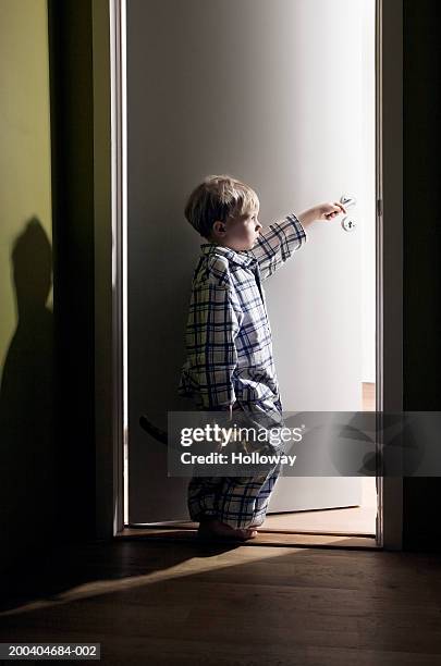 boy (2-4) holding toy dinosaur standing in light of doorway - dinosaur toy i stock pictures, royalty-free photos & images