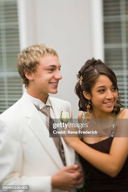 teenage girl (14-16) placing corsage on teenage boy (14-16) - corsage imagens e fotografias de stock