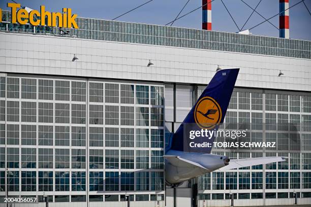 The tail of an airplane belonging to the German carrier Lufthansa is seen poking out from a hangar door at Munich international airport in southern...