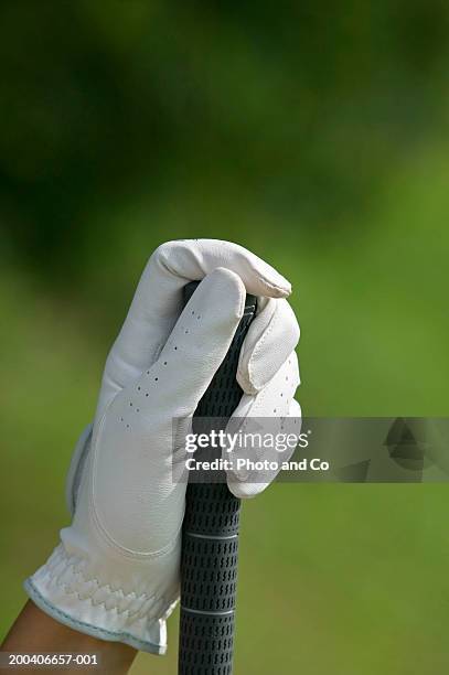 woman holding golf club, close-up of hand - golfhandschuh stock-fotos und bilder