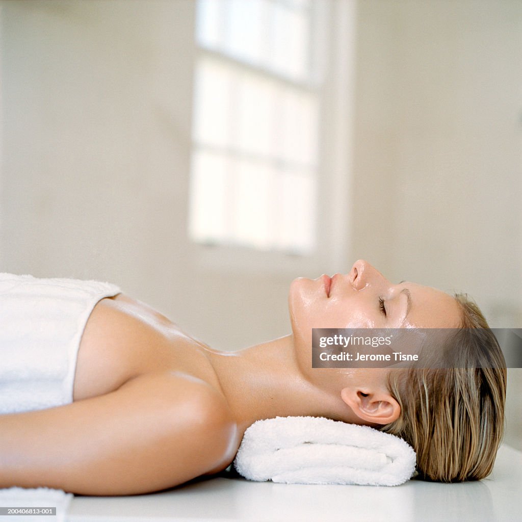 Young woman wearing beauty treatment on face and body, side view