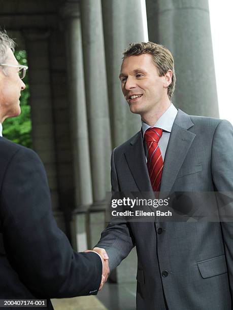 businessmen shaking hands, smiling - gray suit stock pictures, royalty-free photos & images