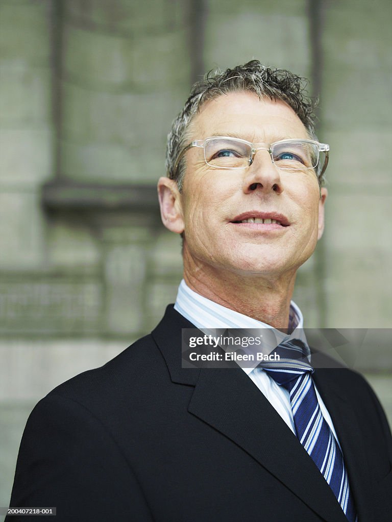 Businessman looking up, smiling, close-up