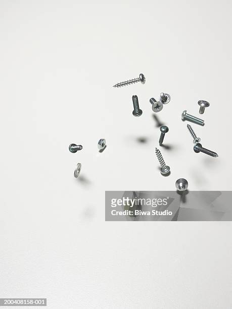 screws, nuts and bolts bouncing on counter, close-up - bolt stock-fotos und bilder