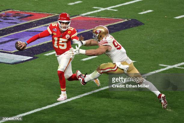 Patrick Mahomes of the Kansas City Chiefs looks to avoid a sack by Nick Bosa of the San Francisco 49ers in the fourth quarter during Super Bowl LVIII...