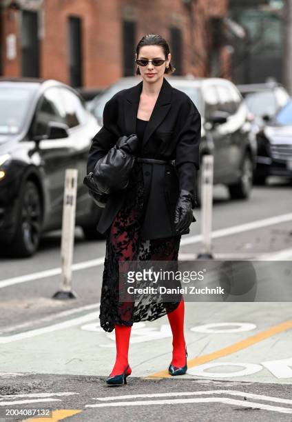 Marina Ingvarsson is seen wearing a black blazer, black top, black sheer sirt, red tights and black heels, black bag and black sunglasses outside the...