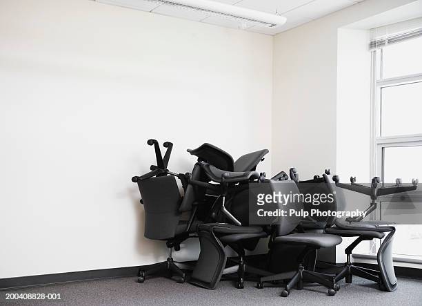 office chairs piled in corner of empty office - omstrukturering bildbanksfoton och bilder