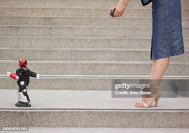 woman on steps using remote control robot, low section, side view - robotic leg stock pictures, royalty-free photos & images