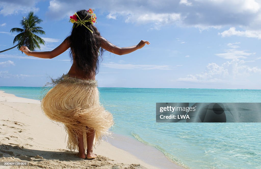 Native dancer on beach, rear view