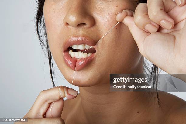 woman flossing teeth - zahnseide stock-fotos und bilder