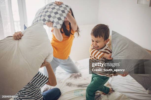 un gruppo di bambini che litigano con i cuscini - birichinata foto e immagini stock