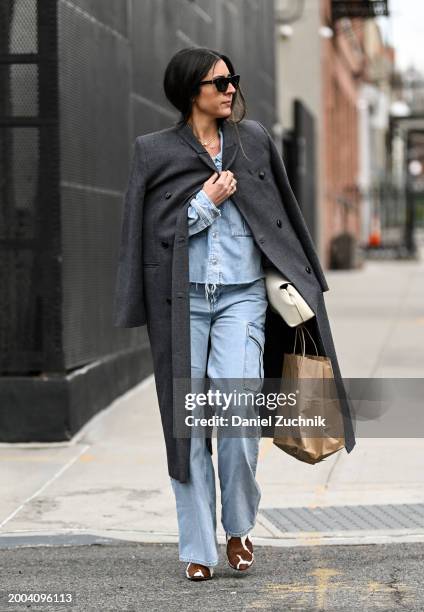 Guest is seen wearing a gray coat, denim top and pants with cream bag outside the Jason Wu show during NYFW F/W 2024 on February 11, 2024 in New York...