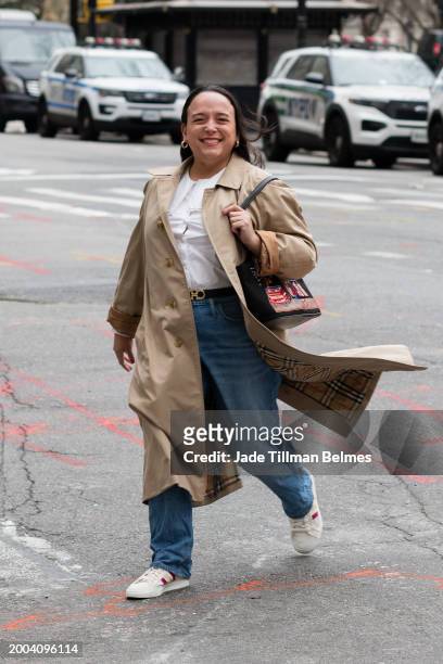 Guest is seen wearing a tan trench coat, white top, blue denim and white sneakers outside the Altuzarra show during February 2024 New York Fashion...