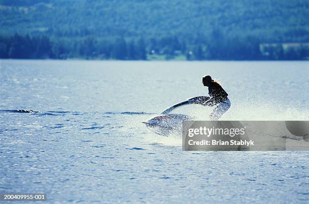 teenage girl (14-16) jetskiing on lake, side view - okanagan valley stock-fotos und bilder