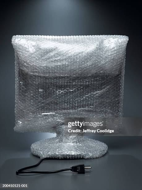 computer wrapped in air cellular cushioning material, rear view - luftpolsterfolie stock-fotos und bilder