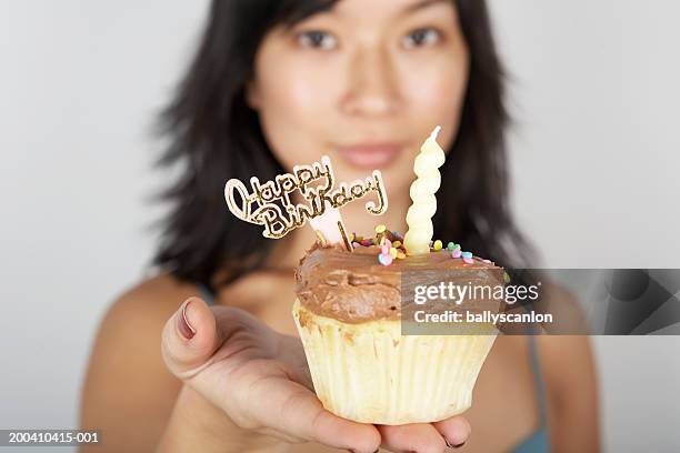 woman holding cupcake with candle and happy birthday sign, portrait - jb of south korean stockfoto's en -beelden