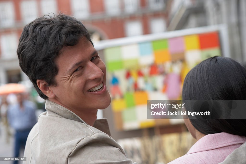 Rear view of a young man looking back and smiling