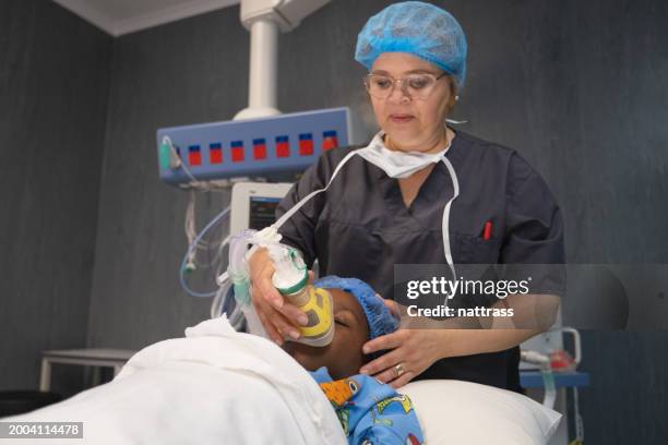 theatre staff prepare a young black girl for surgery - sleep hygiene stock pictures, royalty-free photos & images