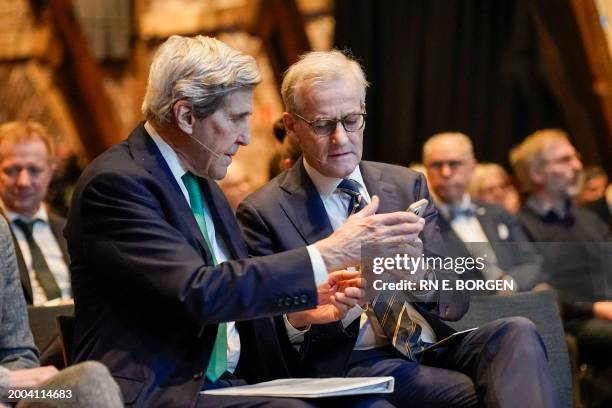 The US special envoy for climate John Kerry and Nowegian Prime Minister Jonas Gahr Store together look at a mobile phone as they attend a summit on...