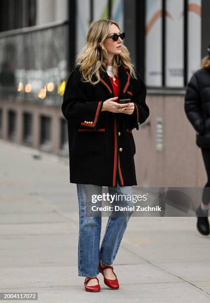 Guest is seen wearing a black and red Gucci jacket, blue jeans and red shoes with black sunglasses outside the Jason Wu show during NYFW F/W 2024 on...