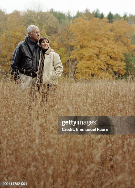 senior couple in overgrown field, autumn - mid distance stock pictures, royalty-free photos & images