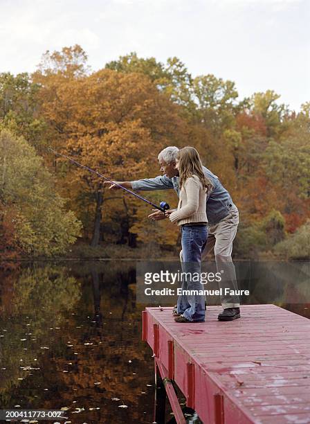 grandfather and granddaughter (8-10) on dock, girl with fishing rod - the new york premiere of the sixth final season of girls stockfoto's en -beelden