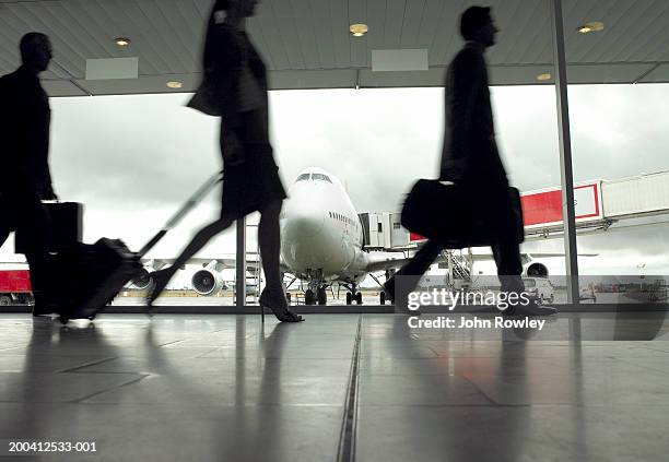 people walking through airport, silhouette (focus on aeroplane) - airplane side view stock pictures, royalty-free photos & images