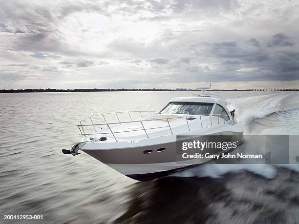 couple relaxing on speed boat, dawn, elevated view - speedboat stock-fotos und bilder