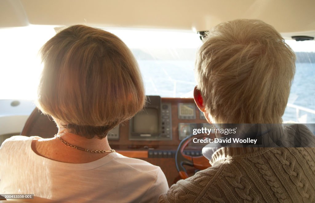 Senior couple on bridge of yacht, close-up, rear view
