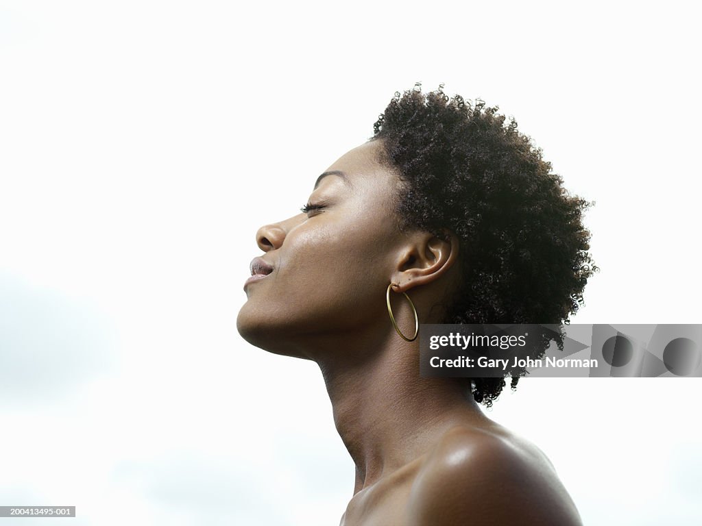 Young woman, eyes closed, low angle view, profile