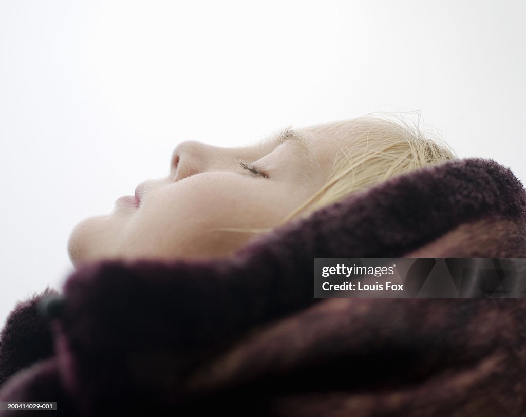 Girl (9-11) tilting head back in rain, eyes closed, profile, close-up