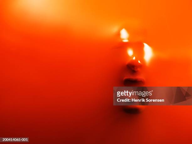 impression of man's face through orange rubber, close-up - shouting face stock pictures, royalty-free photos & images