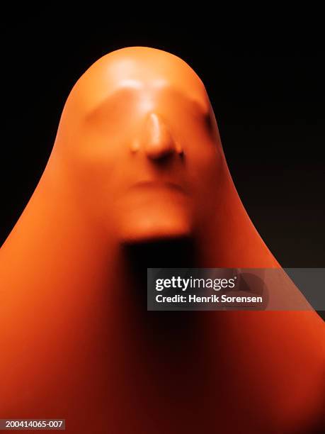 impression of man's face through orange rubber, close-up - aparición conceptos fotografías e imágenes de stock