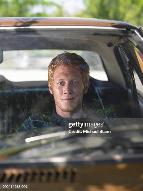 young man in car, smiling, view through windscreen, portrait, close-up - michael sit stock pictures, royalty-free photos & images